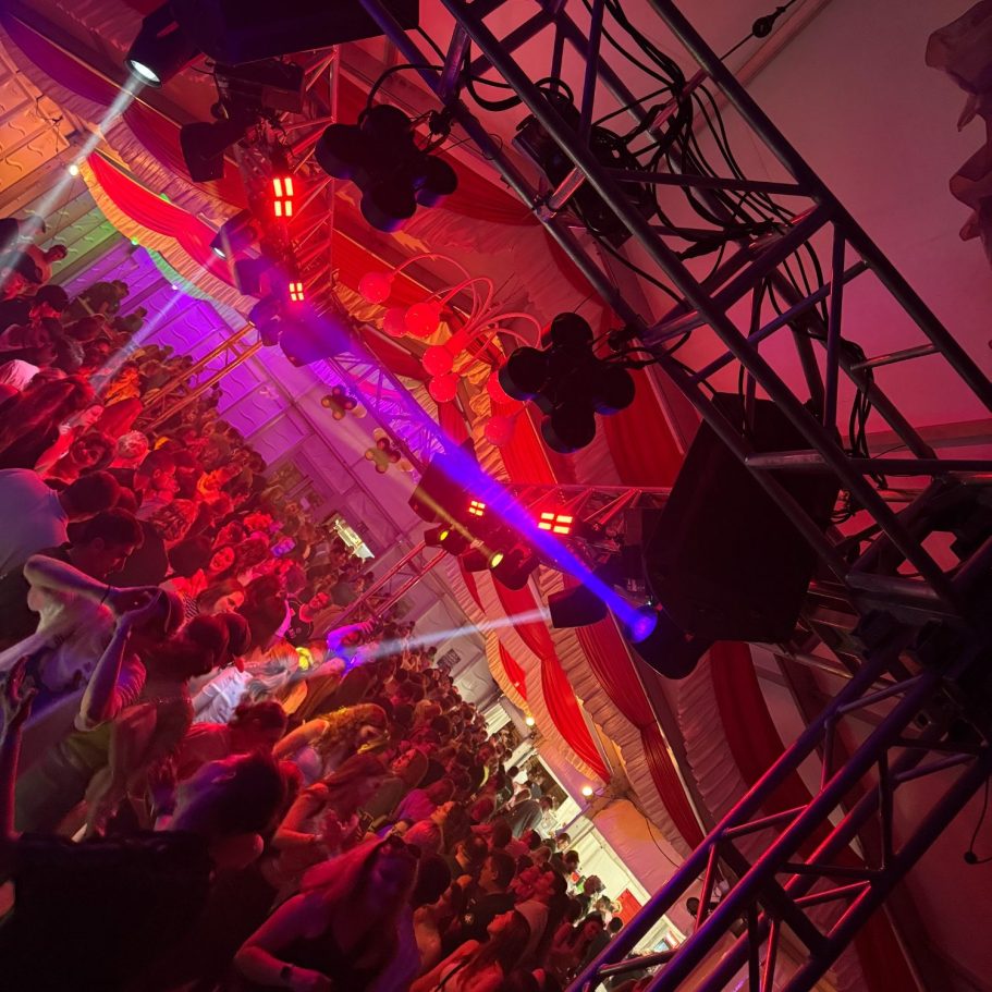 Bunte Lichter und Menschen tanzen in einem Festzelt zur Musik von DJ Driessen.